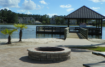 a fire pit with a dock in the background